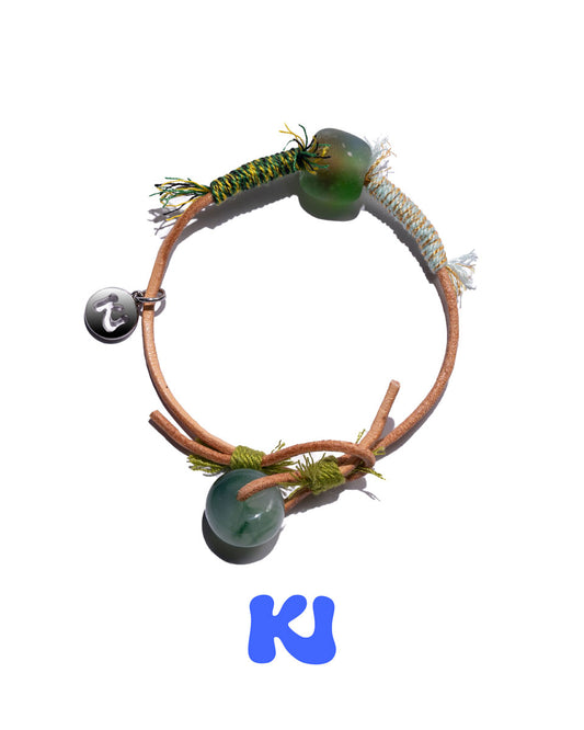 Moss Glade beaded charm bracelet with large green beads and braided cord with fringe