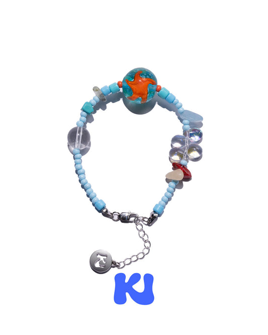 Beaded bracelet with large orange globe bead, clear flower charms, silver clasp