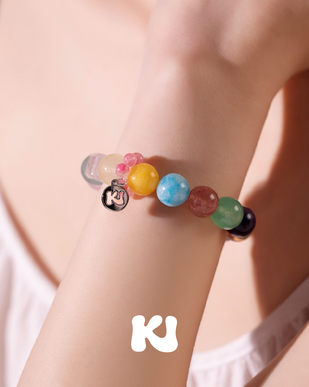 Multi-color round stone bead bracelet with letter charm, on wrist