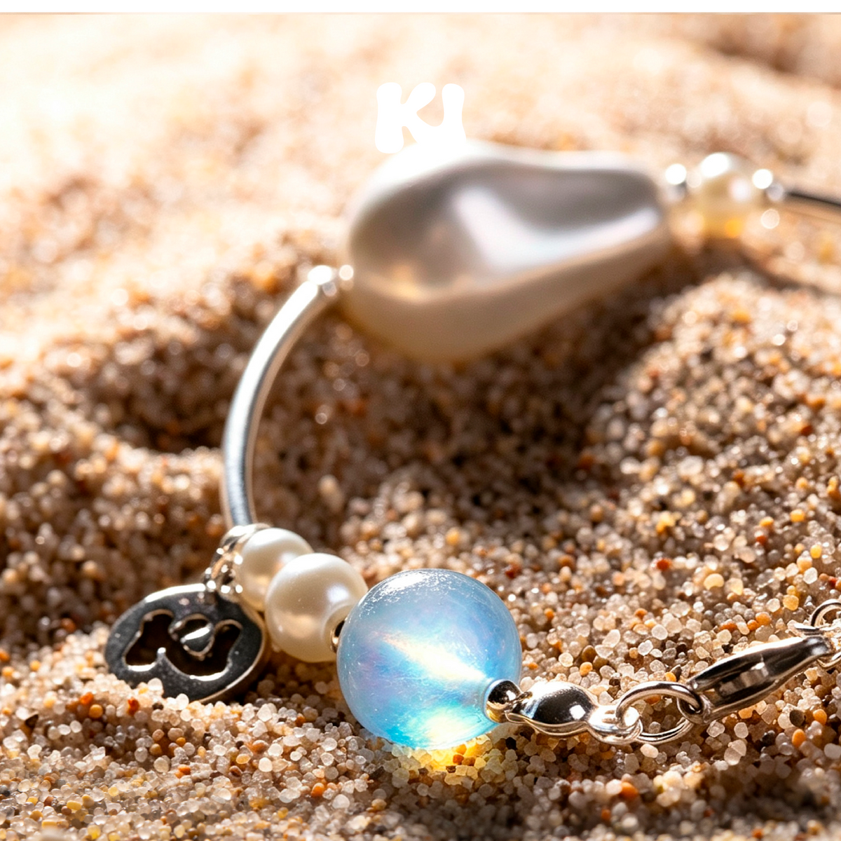 Silver-tone bracelet with blue opalescent moonstone bead, mother-of-pearl charms, pearls