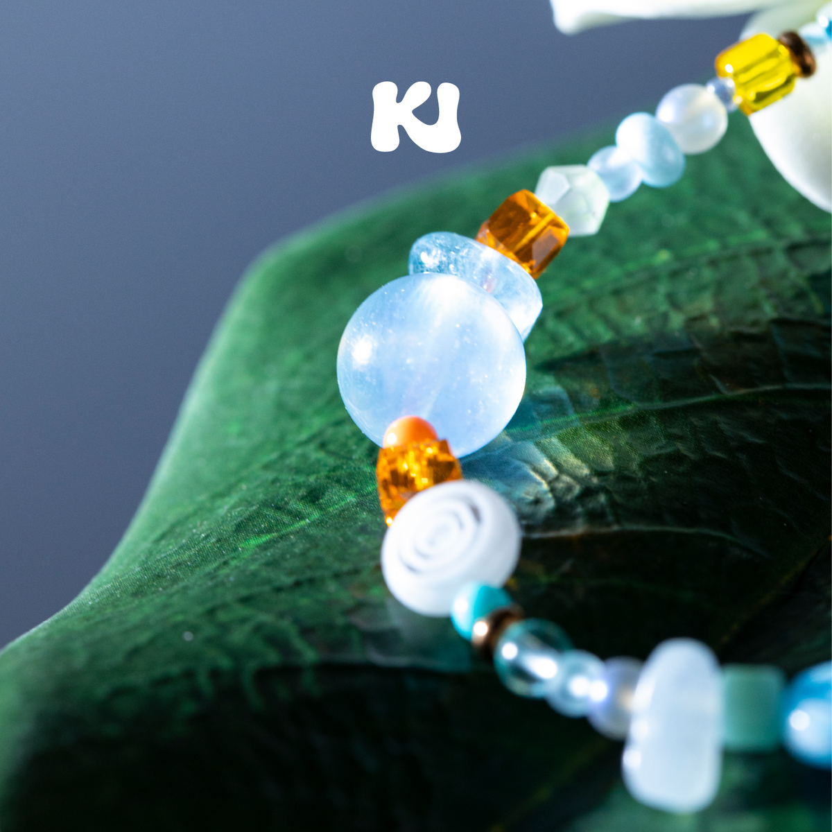 Multicolor seed bead and crystal necklace with light blue round bead pendant detail