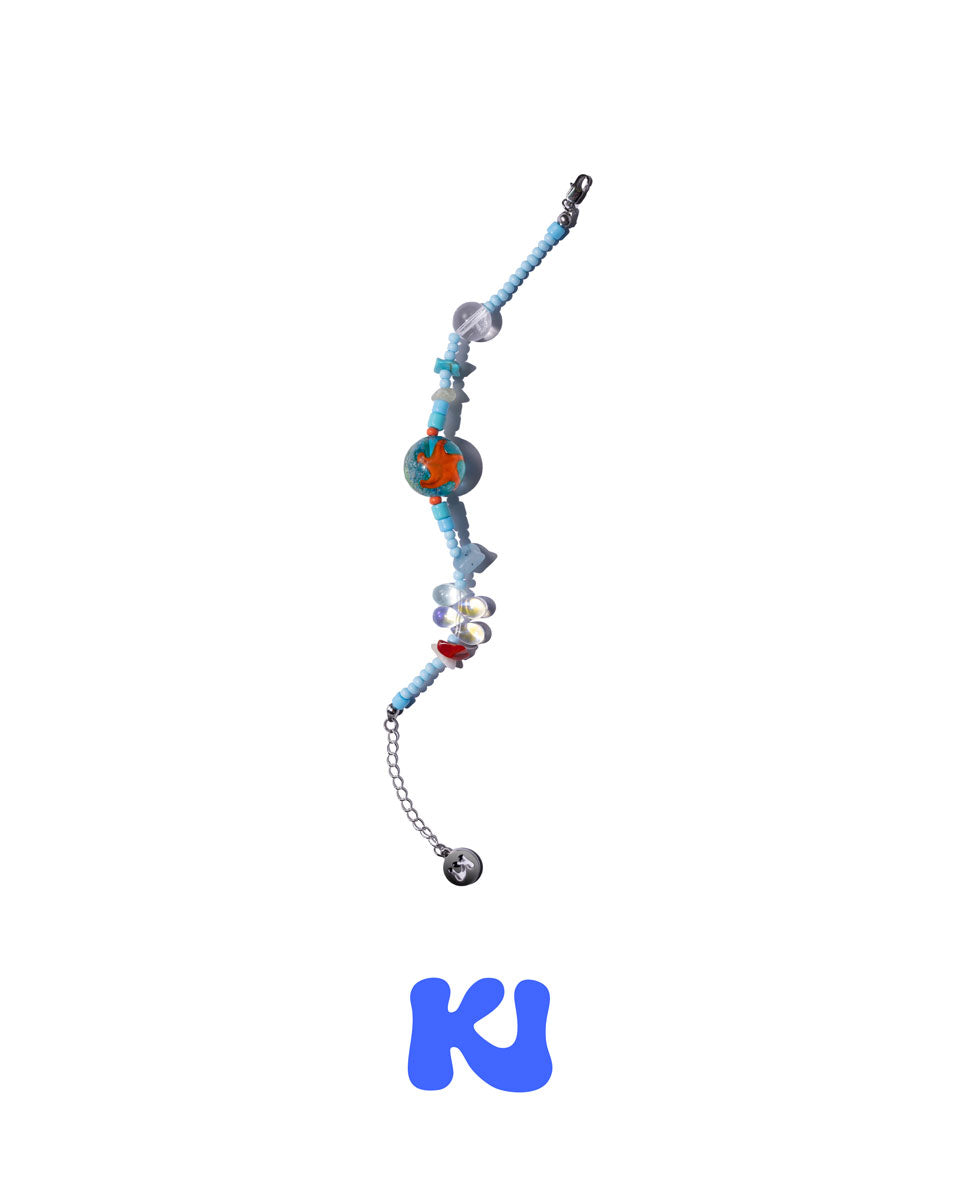 Beaded bracelet with blue beads, orange round centerpiece, silver chain and charms