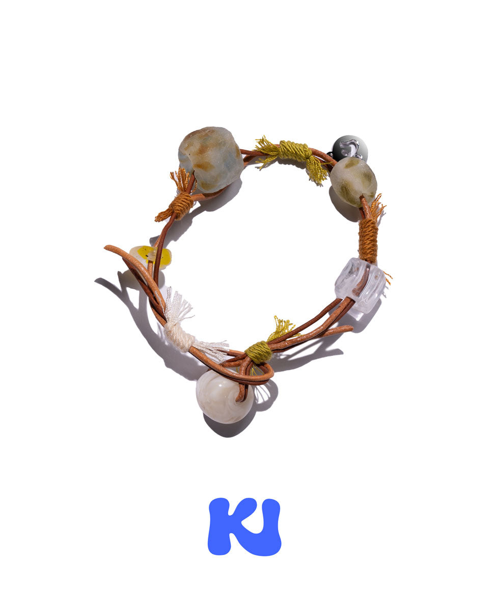Braided rope bracelet with ivory-tone beads, yellow cord, and clear acrylic accents