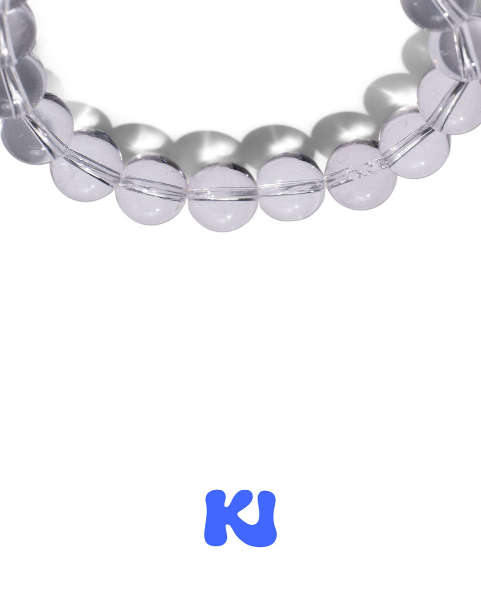 Close-up of clear and silver beaded bracelet with light blue center bead