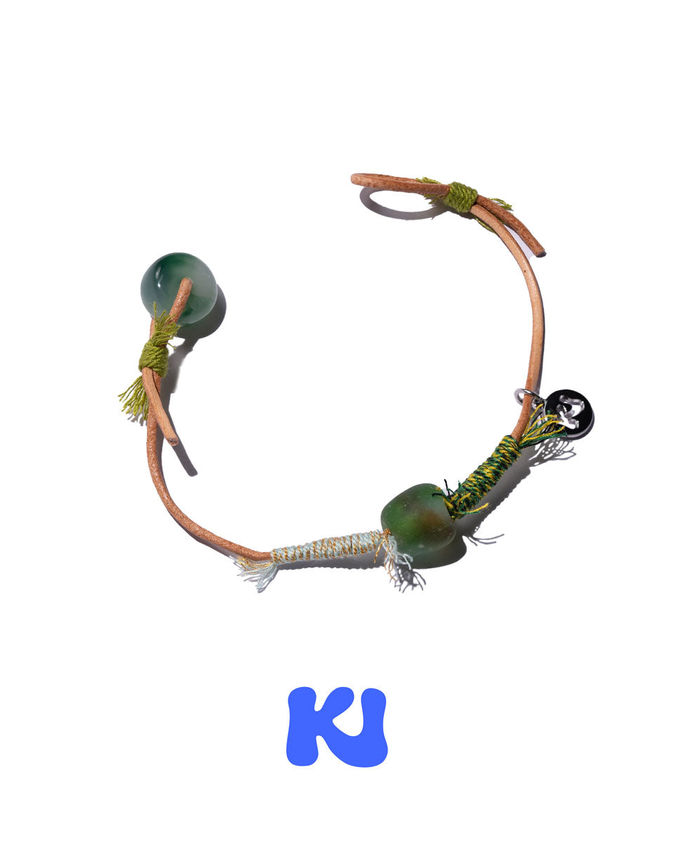 Moss Glade beaded charm bracelet with green oval beads, braided tassels, cord ties