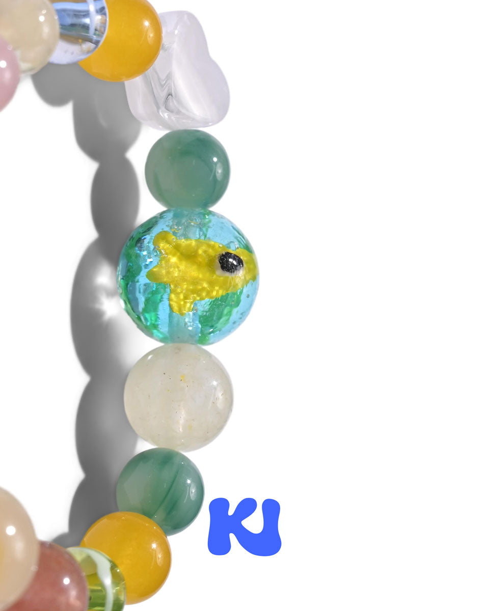 Beaded crystal bracelet with yellow fish-eye charm and translucent green beads