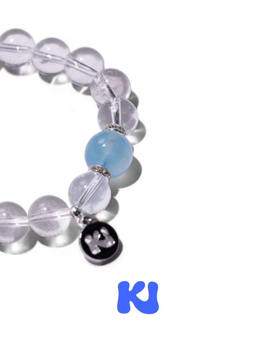 Beaded bracelet with light blue bead and black heart charm detail