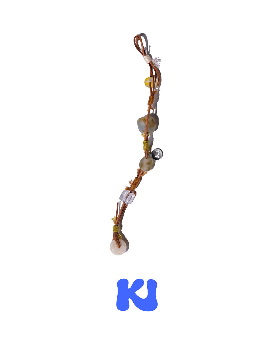 Braided rope bracelet with multiple beads and dangling charms in light gray and amber tones